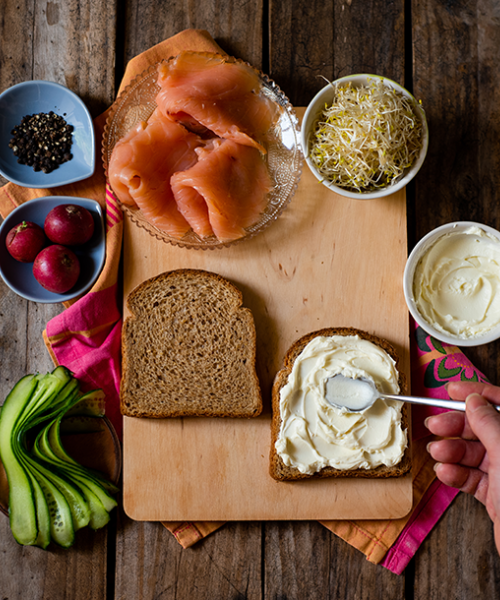 Αλείφουμε τη μία φέτα με cream cheese και τοποθετούμε τον σολομό.